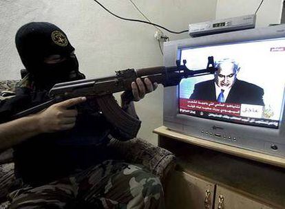 Un militante de la Yihad Islámica apunta con su rifle AK-47 a la televisión durante el discurso del primer ministro israelí, Benjamín Netanyahu.