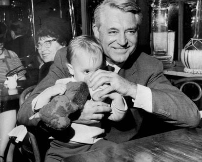 Cary Grant con su hija Jennifer Grant en brazos en un restaurante en 1967.