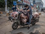 -FOTODELDÍA-PIL01. BEIJING, 13/06/2020.- Hombres con máscaras protectoras cargan un scooter con carne al lado del edificio cerrado del mercado Xinfadi en el distrito de Fengtai, Beijing, China, el 13 de junio de 2020. Uno de los mercados más grandes de Beijing, Xinfadi en el distrito de Fengtai, fue cerrado el 13 de junio, y el distrito colocado bajo bloqueo después de la confirmación de nuevos casos de coronavirus domésticos . EFE/EPA/ROMAN PILIPEY