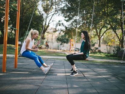 Dos jóvenes charlan en un parque.