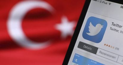 El logotipo de Twitter, en la pantalla de un móvil junto a la bandera turca.