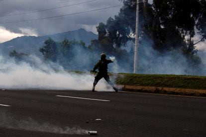Un miembro de las fuerzas de seguridad ecuatorianas lanza un bote de gas lacrimógeno a los manifestantes indígenas que marchan hacia Quito, en Machachi, el 20 de junio de 2022.