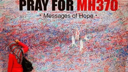 Una mujer escribe un mensaje en un mural en recuerdo de las víctimas del vuelo MH370, en el centro de Kuala Lumpur en marzo de 2014.