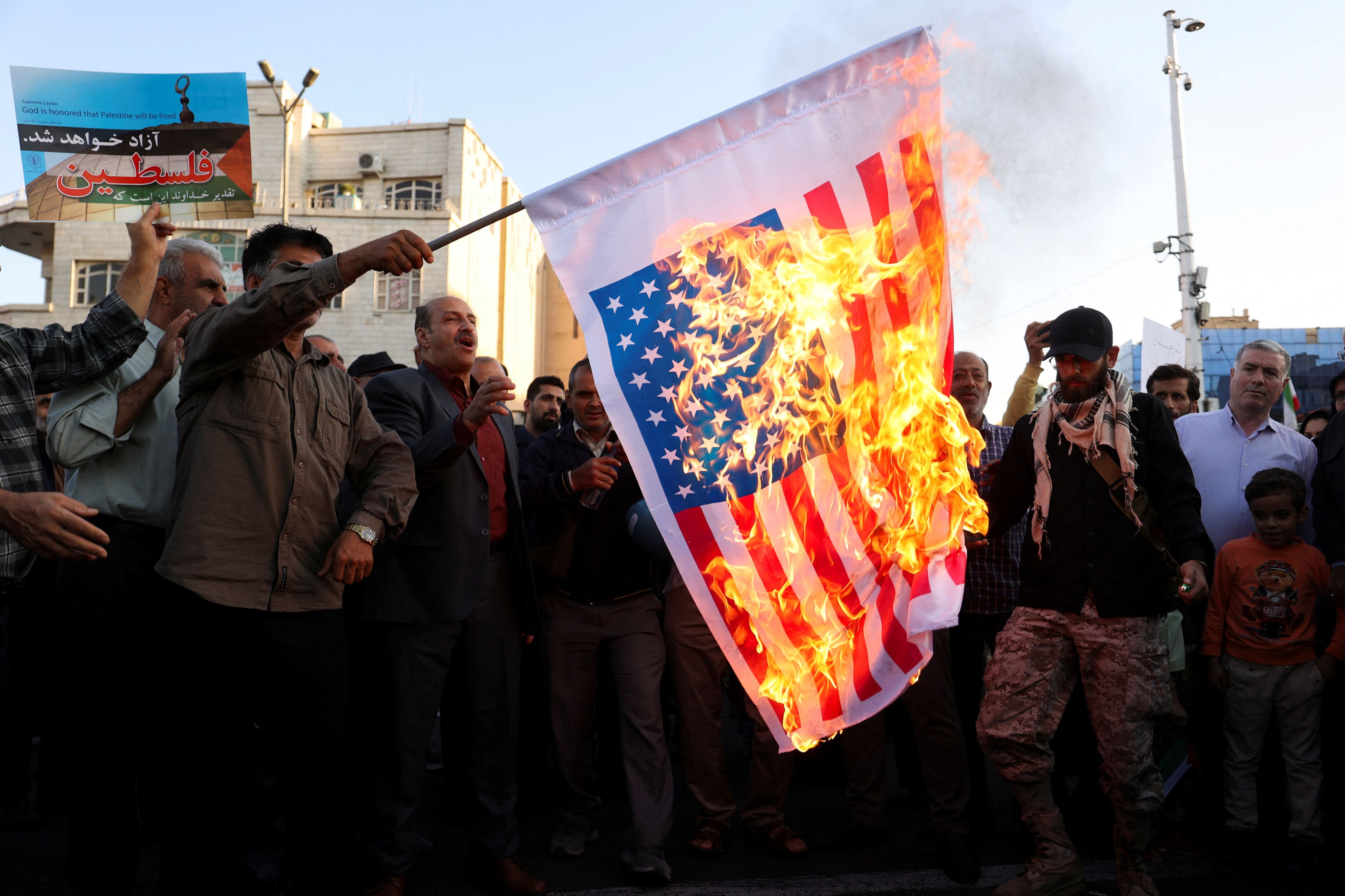 Varios hombres quemaban una bandera de Estados Unidos durante un protesta en Teherán (Irán), el miércoles. 