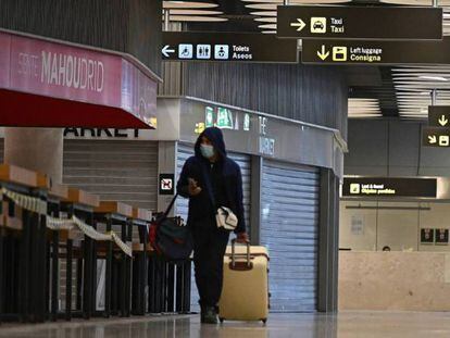  Un pasajero camina por el aeropuerto de Barajas entre tiendas y bares cerrados. 