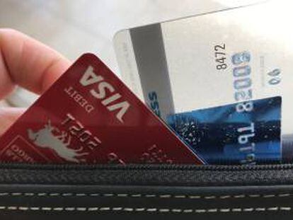Una persona retira una tarjeta de su bolso de mano.