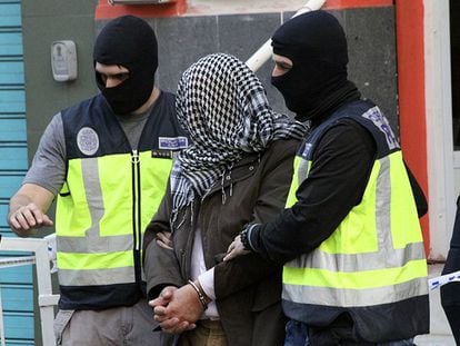 La policía traslada a uno de los detenidos en Ceuta este domingo.
