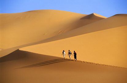 Varias personas caminan por el desierto del Sáhara, cerca de Djanet (Argelia). 