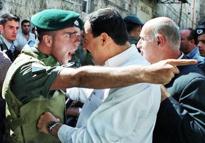 Un policía israelí y un civil palestino se enfrentan en Jerusalén, en 2000.