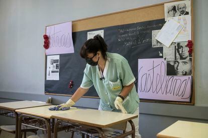 Una trabajadora limpia una aula de un instituto de Barcelona.