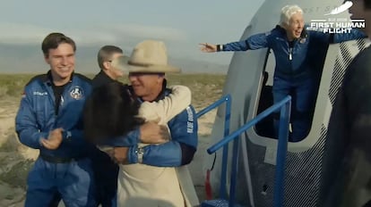 Bezos, con sombrero texano, se abraza nada más salir de la cápsula, con el joven Oliver Daemen a la izquierda y la piloto Wally Funk saludando desde la escotilla.