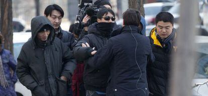 Un oficial chino empuja a un periodista extranjero para alejarlo del tribunal donde se estaba juzgando a Xu Zhiyong.
