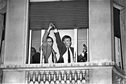 Alfonso Guerra levanta la mano de Felipe González, asomados ambos a una ventana del hotel Palace de Madrid, celebrando la histórica victoria del PSOE.