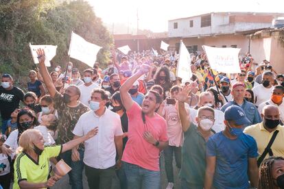 El candidato por la Mesa de la Unidad, José Manuel Olivares, saluda a unos simpatizantes mientras camina junto al excandidato a la gobernación de Miranda, Carlos Ocariz, en La Guaira, Venezuela, el 14 de noviembre.
