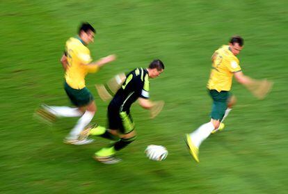 Fernando Torres avanza con el bal&oacute;n escoltado por los australianos Mile Jedinak (i) y Alex Wilkinson. 