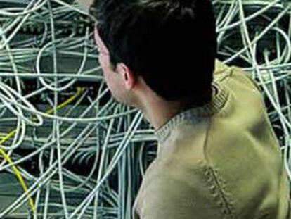 Un ingeniero conecta cables telefónicos en una central