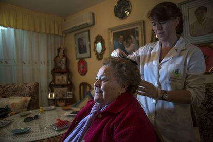 La cuidadora Ana María López atiende a Antonia Carrasco en su casa de Jaén.