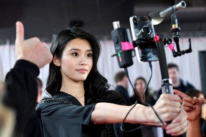 La modelo china Ming Xi se hace un sofisticado 'selfie' durante el 'backstage' del desfile de Victoria's Secret.