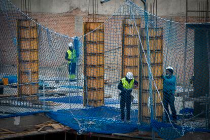 Varios trabajadores de la construcción en un edificio de Madrid, este martes. 