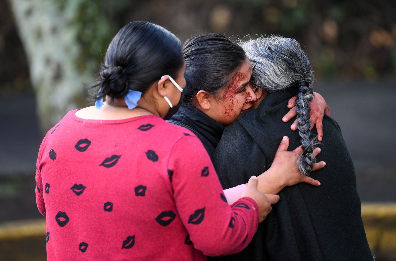 Los familiares de un transeúnte que murió el ataque, lloran en la escena del crimen.
