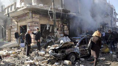 Policías sirios inspeccionan el lugar donde se ha producido un atentado en una zona residencial en Homs.