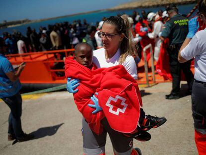 Una miembro de la Cruz Roja acoge a un niño rescatado de una patera en el estrecho de Gibraltar el pasado día 4 de julio.
