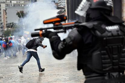 Un agente de la policía antidisturbios dispara hacia los manifestantes en la plaza Bolívar de Bogotá en las protestas de la huelga nacional, este miércoles.
