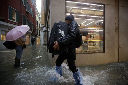 Un hombre sostiene su equipaje mientras camina por el agua en Venecia,  después de haber sufrido las peores inundaciones en 50 años. 
