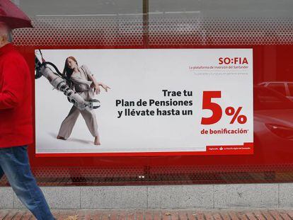 Una persona pasa delante de una cartel que anuncia planes de pensiones.