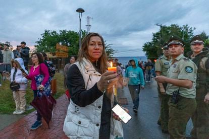 Una mujer con una vela, a orillas de lago Ranco, este martes tras el accidente del exmandatario.