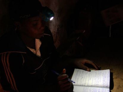 Diane Kanyamuneza, de 18 años, huérfana, estudia en su pequeña cabaña con ayuda de una de las lámparas recargables del Proyecto Lumiere.