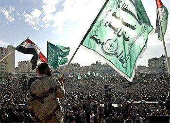 Activistas de Hamás ondean banderas, incluida la iraquí, en la conmemoración en Gaza de su 15º aniversario.