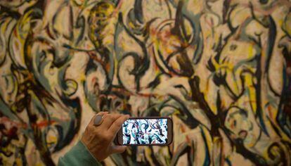 Un visitante toma una foto de la pintura &#039;Mural&#039; (1943) de Jackson Pollock en la exhibici&oacute;n de la Royal Academy londinense.