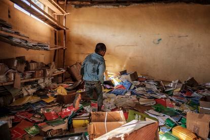 Un niño camina entre libros en la biblioteca de una antigua escuela primaria dañada durante los enfrentamientos en la región de Tigray en Etiopía, en el pueblo de Bisober, el 9 de diciembre de 2020. Las fuerzas de Tigray se instalaron allí siete meses antes del comienzo del conflicto, utilizándolo como base militar.