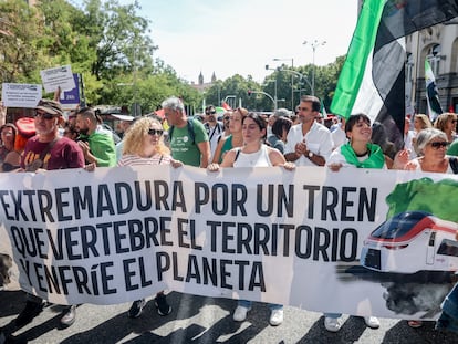 Un grupo de personas sostiene una pancarta durante una concentración por un tren “digno” para Extremadura, frente al Congreso de los Diputados.