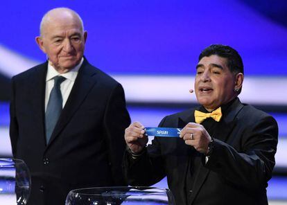 El exfutbolista Diego Maradona (derecha) muestra la papeleta de España durante el sorteo.