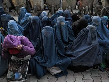 Mujeres afganas esperan pan gratis frente a una panadería este lunes en Kabul (Afganistán).