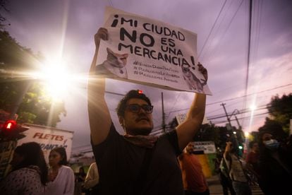 Un joven sostiene un cartel con la frase "Mi ciudad no es una mercancia", durante una protesta en CIudad de México, el 17 de noviembre de 2022. 