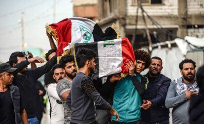 Un grupo de iraquíes lleva este jueves el ataúd de un fallecido en Bagdad.