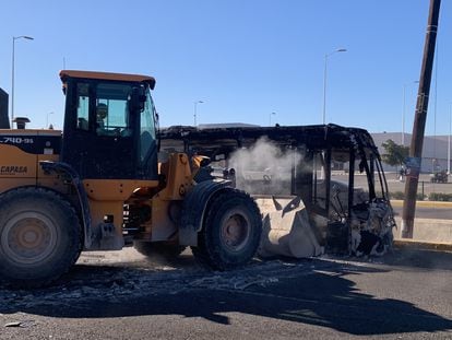 Grúa remueve los restos de un autobús carbonizado en los enfrentamiendos del 5 de enero en Culiacán, Sinaloa