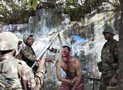 Soldados de Comoras y de la Unión Africana golpean a un hombre acusado de colaborar con los rebeldes, el martes en la isla de Anjouan.