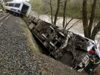 Un bombero supervisa uno de los vagones de un tren descarrilado.