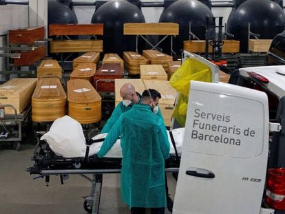 Dos empleados trasladan los restos de una víctima de covid en un tanatorio de Barcelona, el pasado lunes.