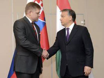 El primer ministro húngaro, Viktor Orban (dcha), estrecha la mano de su homólogo eslovaco, Robert Fico, durante el Foro Económico Húngaro-eslovaco celebrado en la Cámara de Comercio en Budapest (Hungría) hoy.