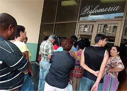 Varias personas esperan para comprar en una perfumería en el barrio El Vedado de La Habana.