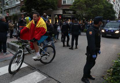 Un hombre circula con su bicicleta entre policías antes de la protesta.