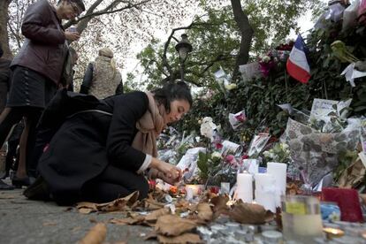 Una dona encén una espelma davant de la sala Bataclan, aquest dimarts a París.