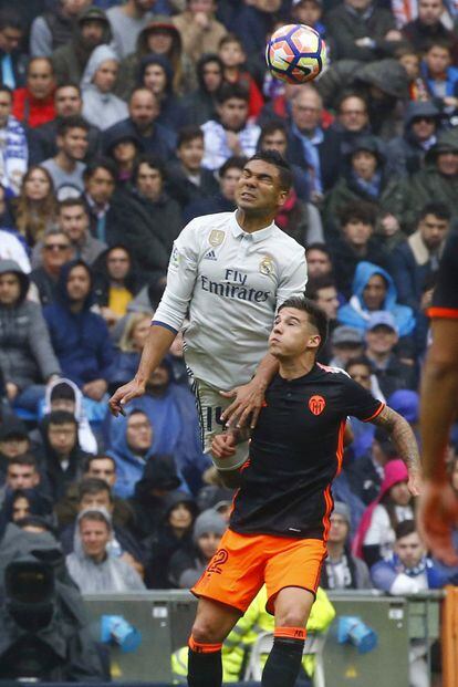 El centrocampista brasileño del Real Madrid Caseimiro (I) disputa un balón con el delantero del Valencia Santi Mina.