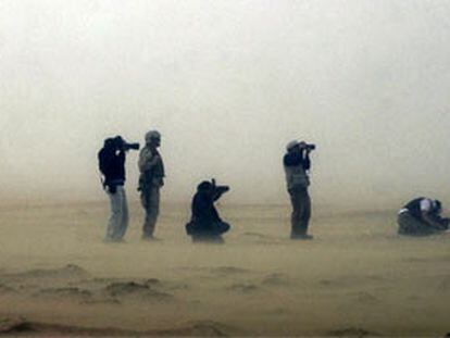 Varios fotógrafos de prensa y <b><i>marines</b></i> estadounidenses, durante una tormenta de arena en el desierto de Kuwait.