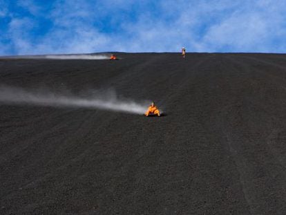 Turistas descendiendo la ladera del volcán Cerro Negro sobre una tabla ('volcanboard'), al noroeste de Nicaragua.